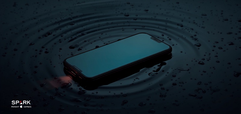 iPhone лежить на сухому рушнику поруч із краплями води, перша допомога після потрапляння вологи