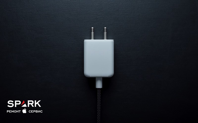 Білий блок живлення USB-C з європейською вилкою і плетений кабель на темній поверхні